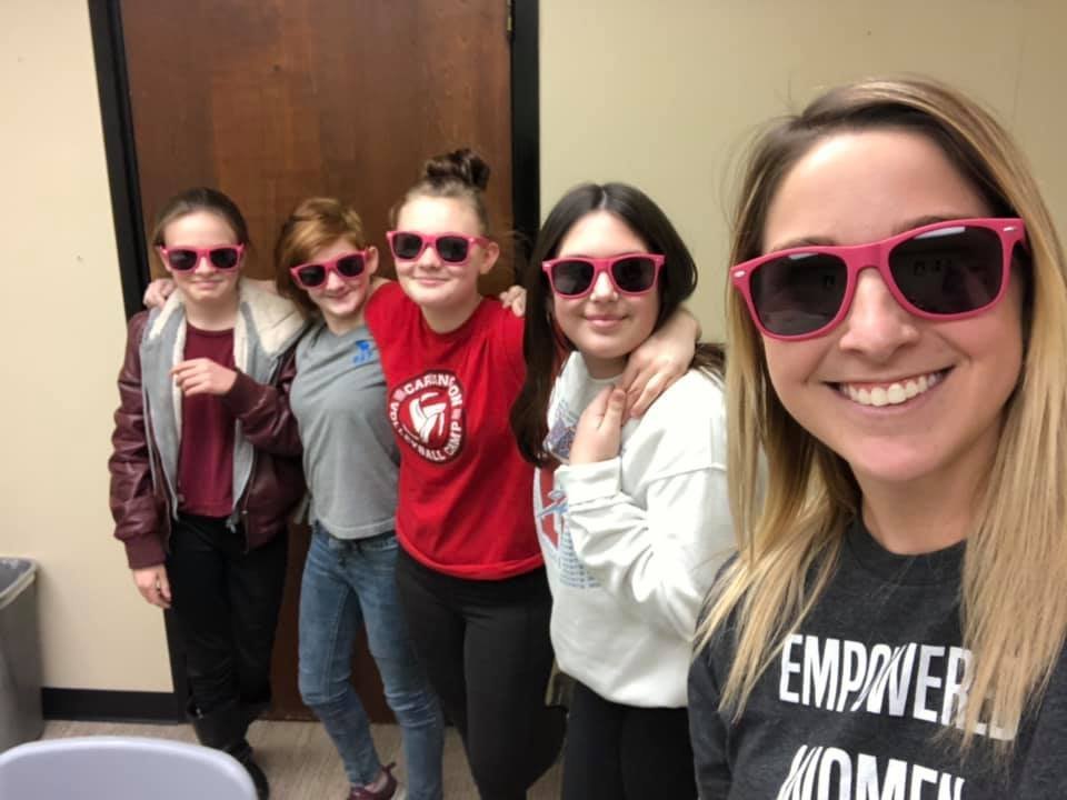 A ROX facilitator and group of girls wearing pink sunglasses